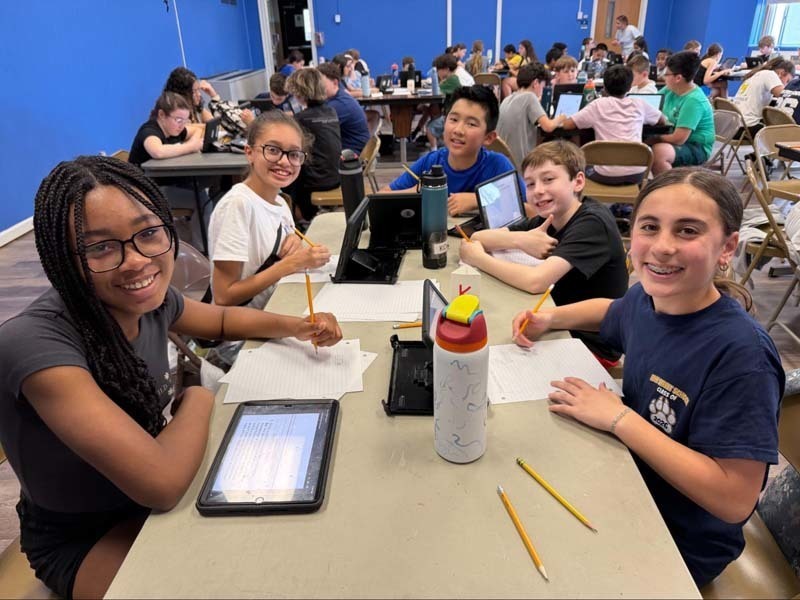 Students sitting at table participatng in challenge.