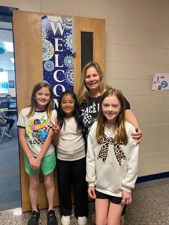 teacher smiling with 3 students