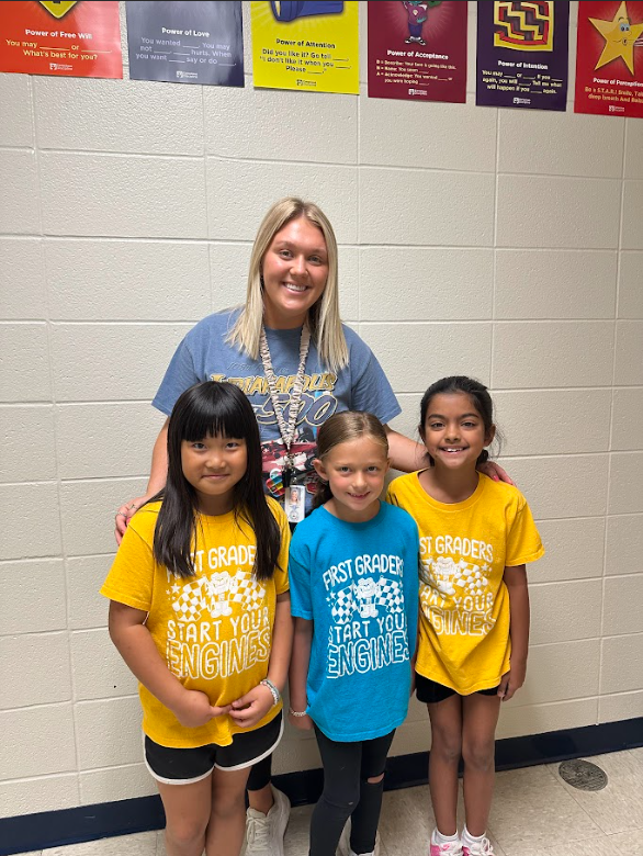 teacher smiling with 3 students