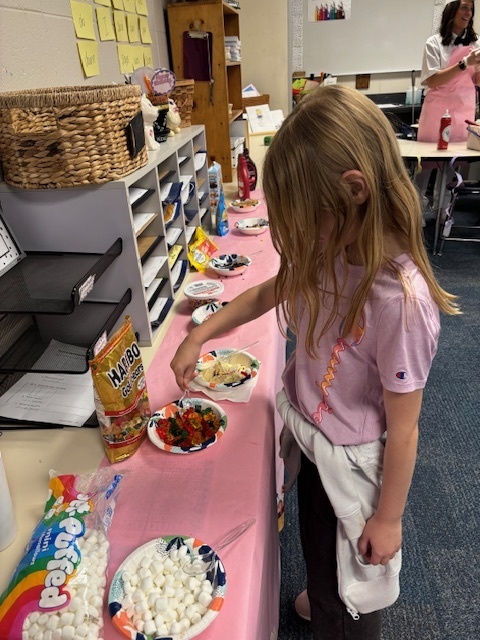 student putting toppings on top of ice cream