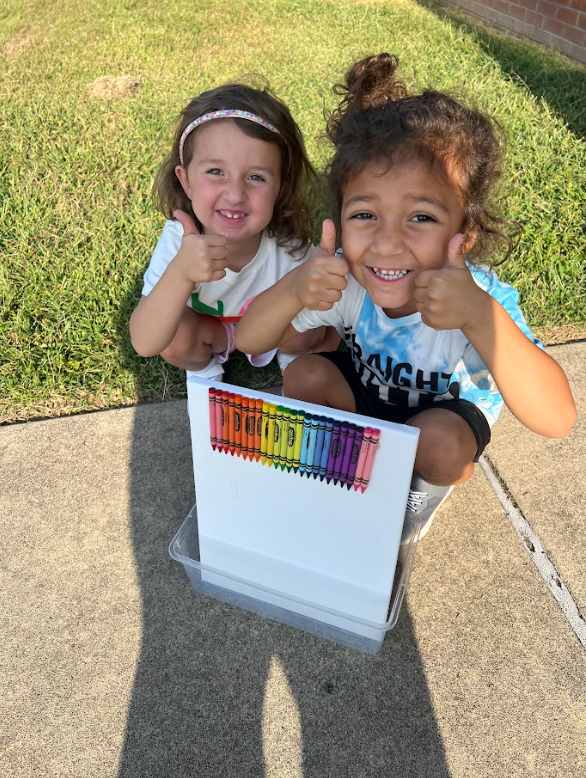 2 kindergarten students smiling giving thumbs up