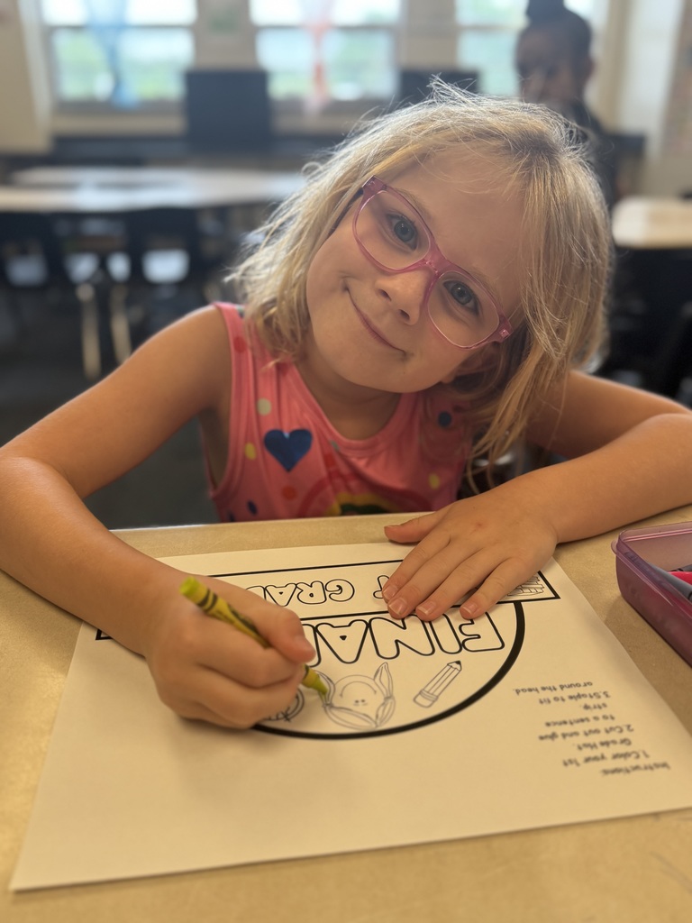 First grade student coloring a coloring sheet