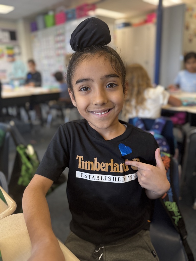 Student smiling with a blue heart sticker