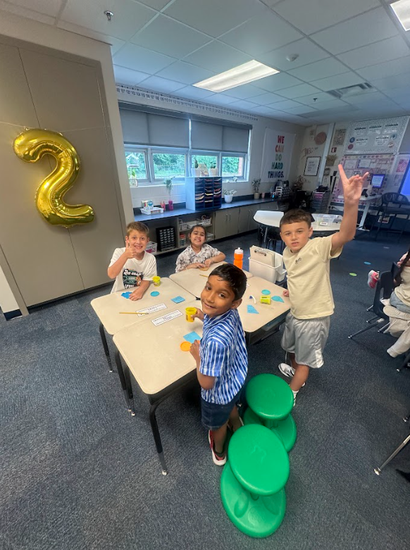 group of 2nd grade students at their desks smiling