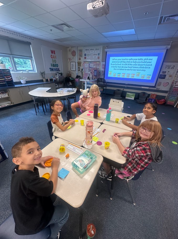 group of 2nd grade students at their desks smiling