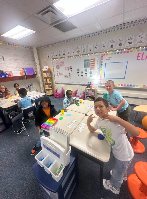 group of 2nd grade students at their desks smiling