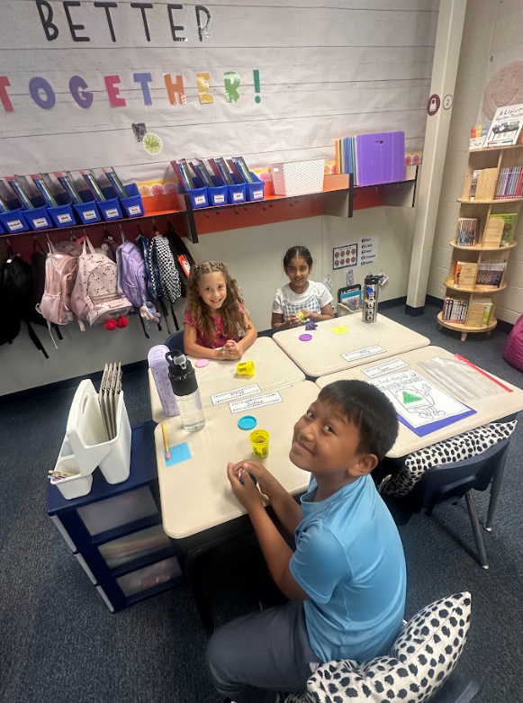 group of 2nd grade students at their desks smiling