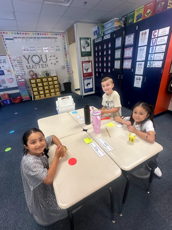 group of 2nd grade students at their desks smiling