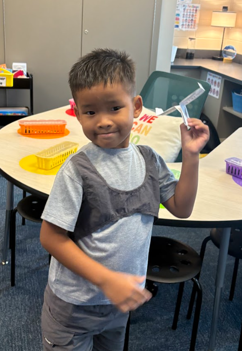 Student holding paper airplane
