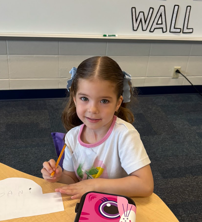 Student smiling holding a pencil