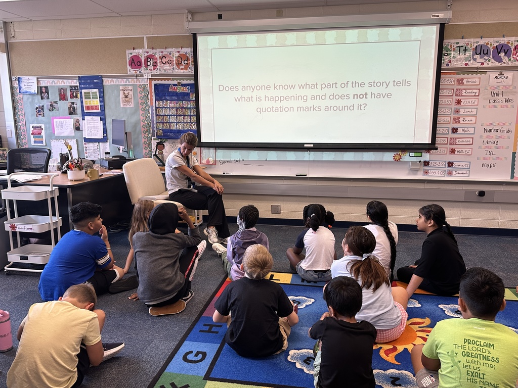 Third grade students sitting on classroom carpet 