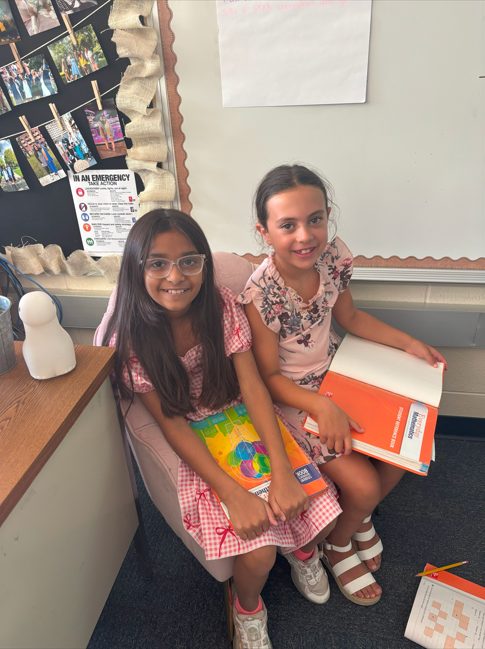 two students doing school work smiling
