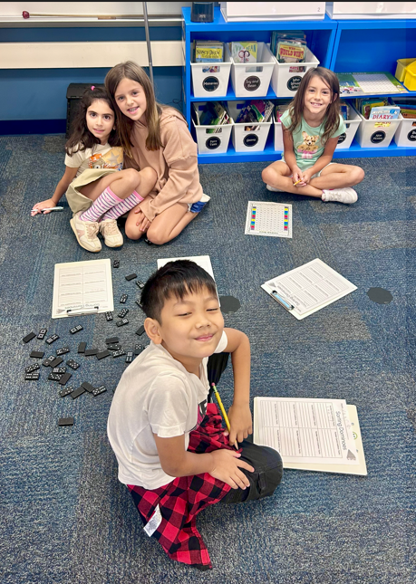 students working with dominos on the floor