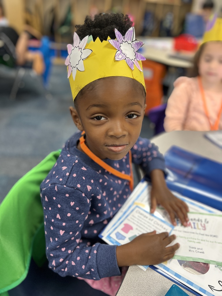 Student with yellow paper crown sitting at table