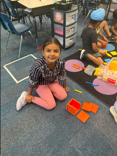 student smiling with number blocks