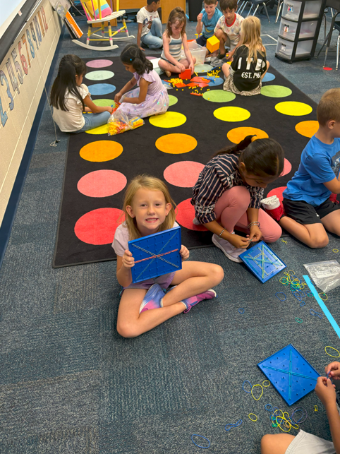 student smiling with geoboard
