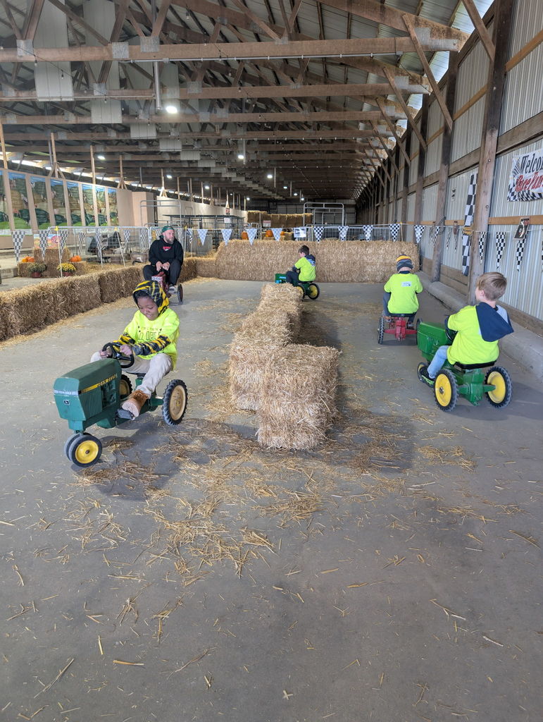 kindergarten students on pedal tractors