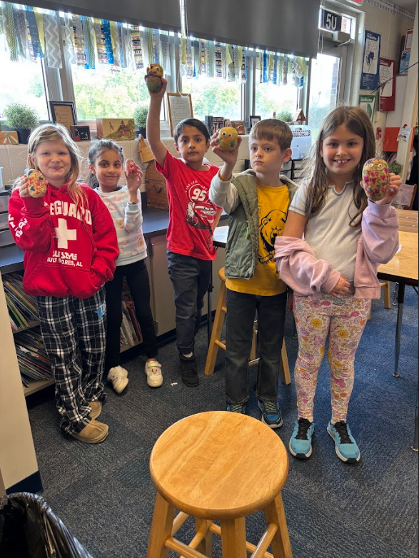 Students holding up potatoes