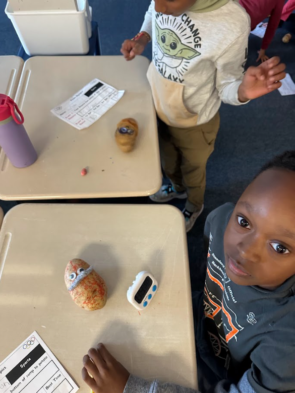 Students holding up potatoes