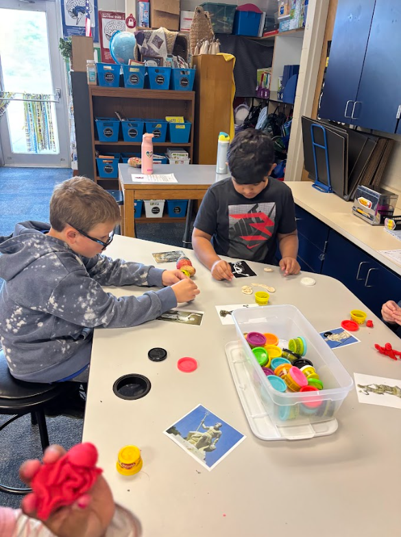 Students holding up potatoes