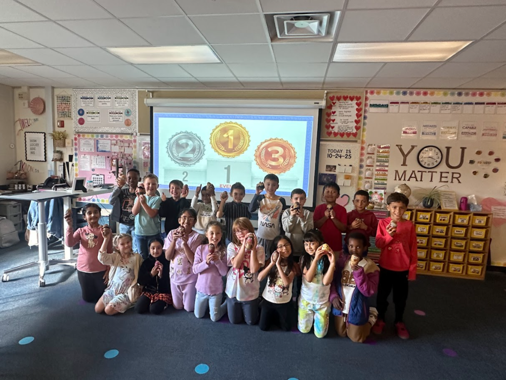 Students holding up potatoes