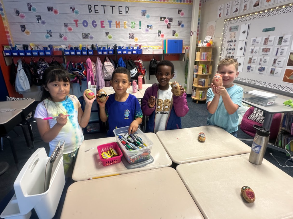 Students holding up potatoes