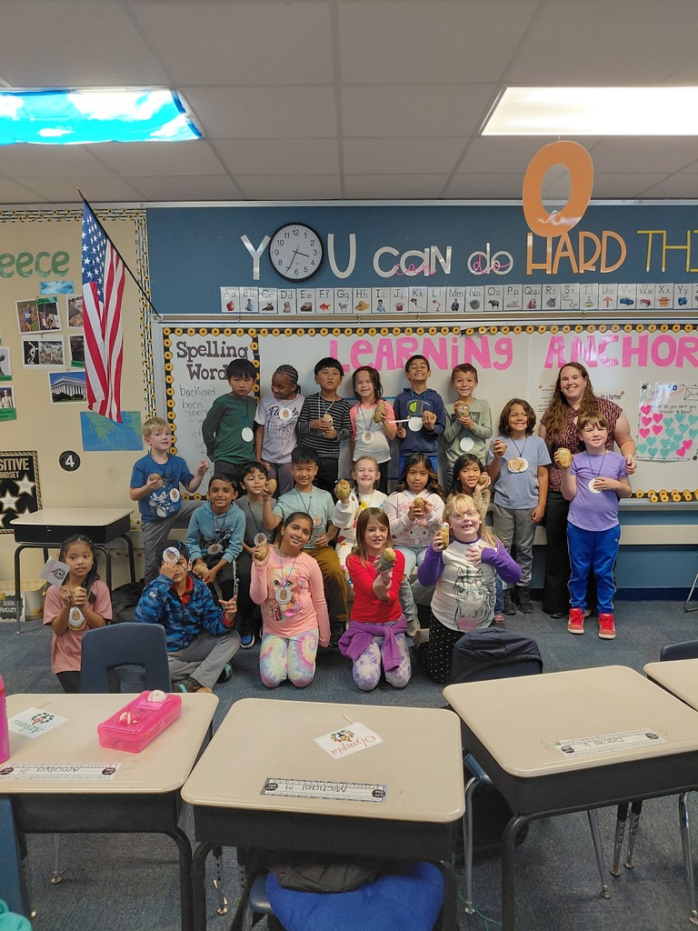 Students holding up potatoes