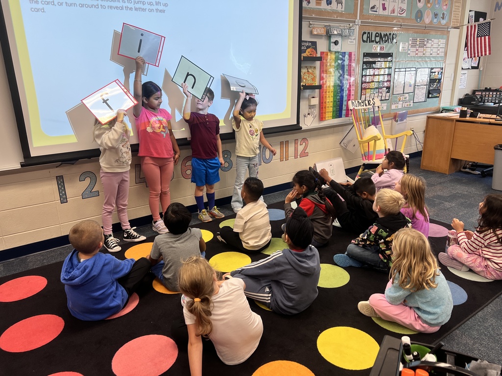 students holding up letter cards working on the magic e rule
