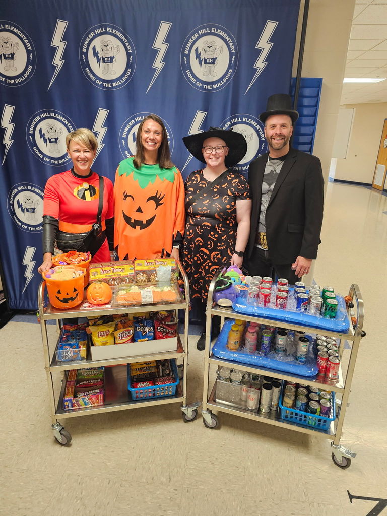 Staff smiling with our Halloween themed snack cart