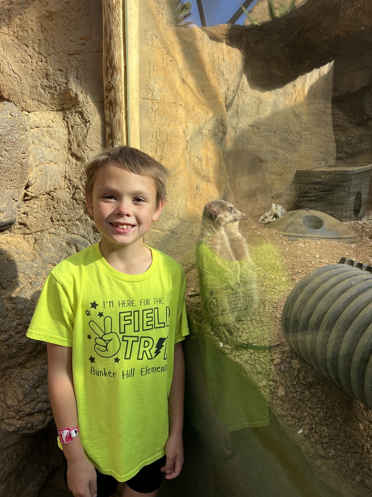 Student smiling with a meerkat at the Indy Zoo