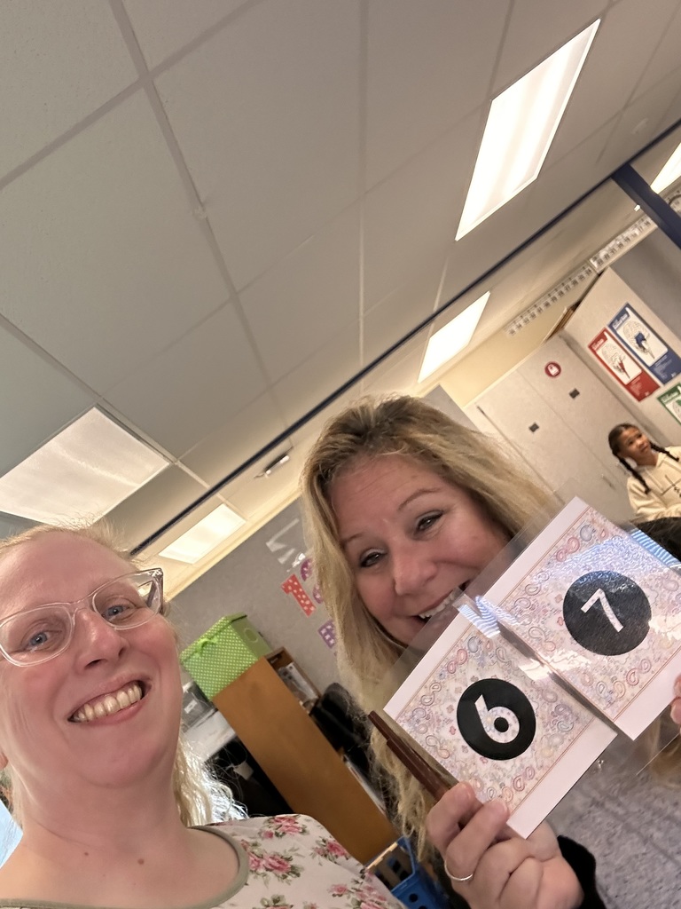 Teachers holding up their matching "6" "7" cards