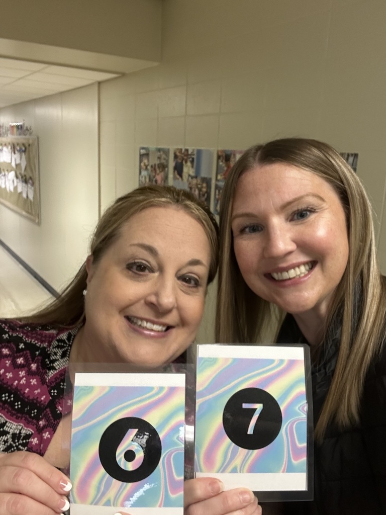 Teachers holding up their matching "6" "7" cards