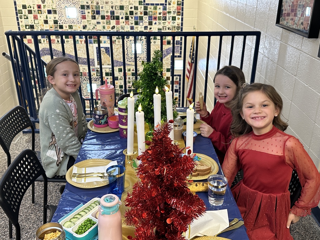 Students at a table eating a lunch with the principal