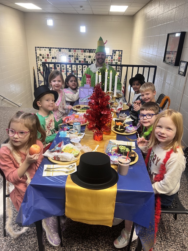 Students at a table eating a lunch with the principal