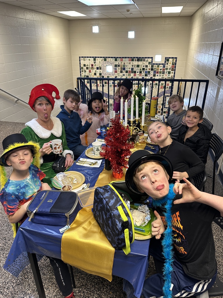 Students at a table eating a lunch with the principal
