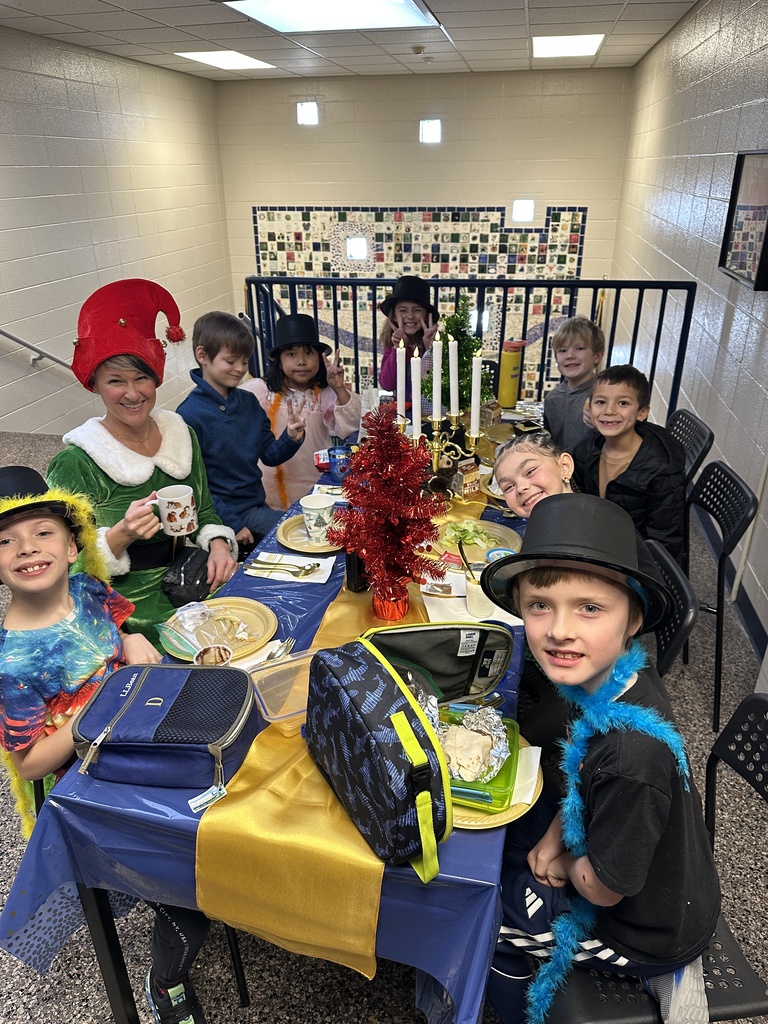 Students at a table eating a lunch with the principal