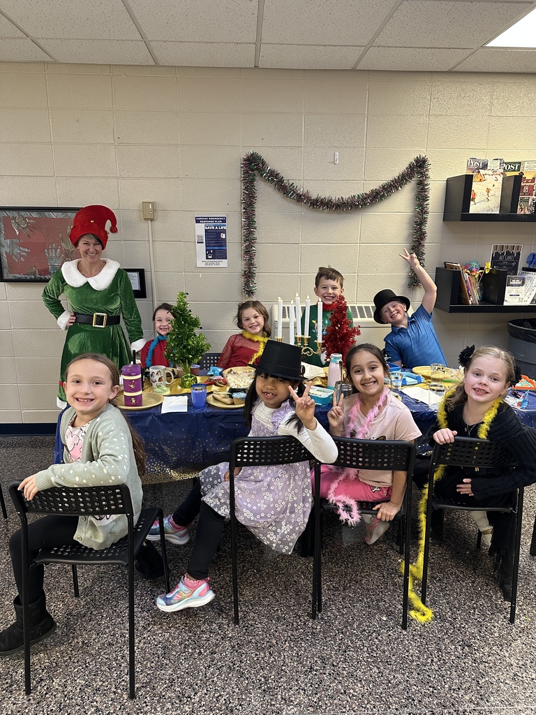 Students at a table eating a lunch with the principal