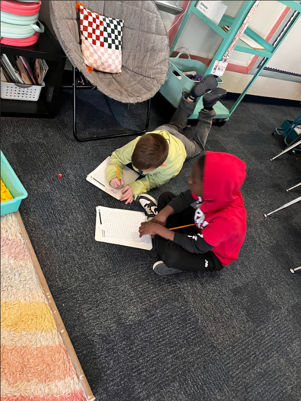 two students working together on the floor