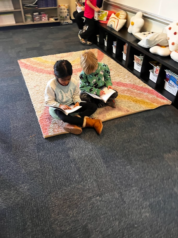 two students working together on the floor