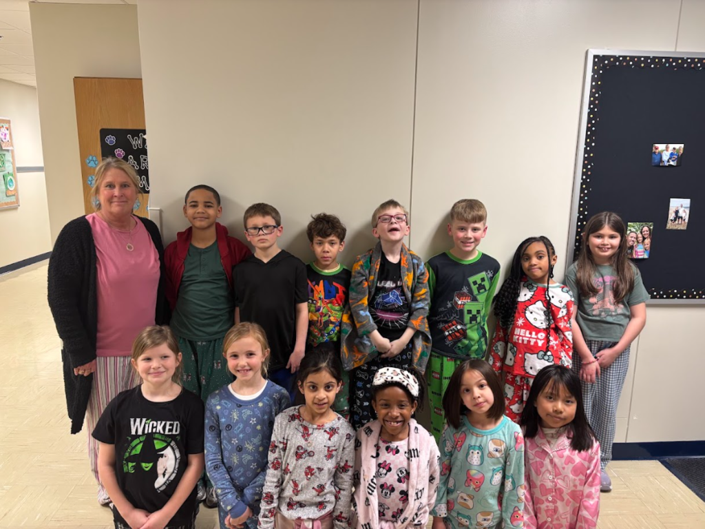Mrs. Kiel's second grade class posing together in the hallway during pajama day