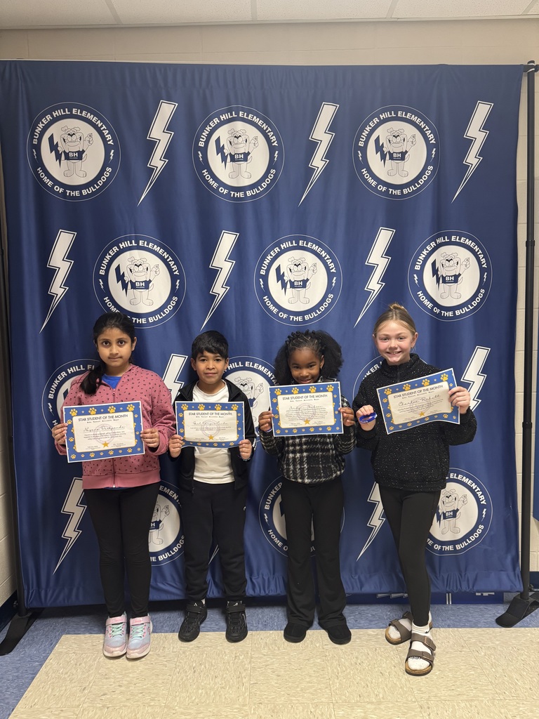 Third grade star students of the month holding their certificates