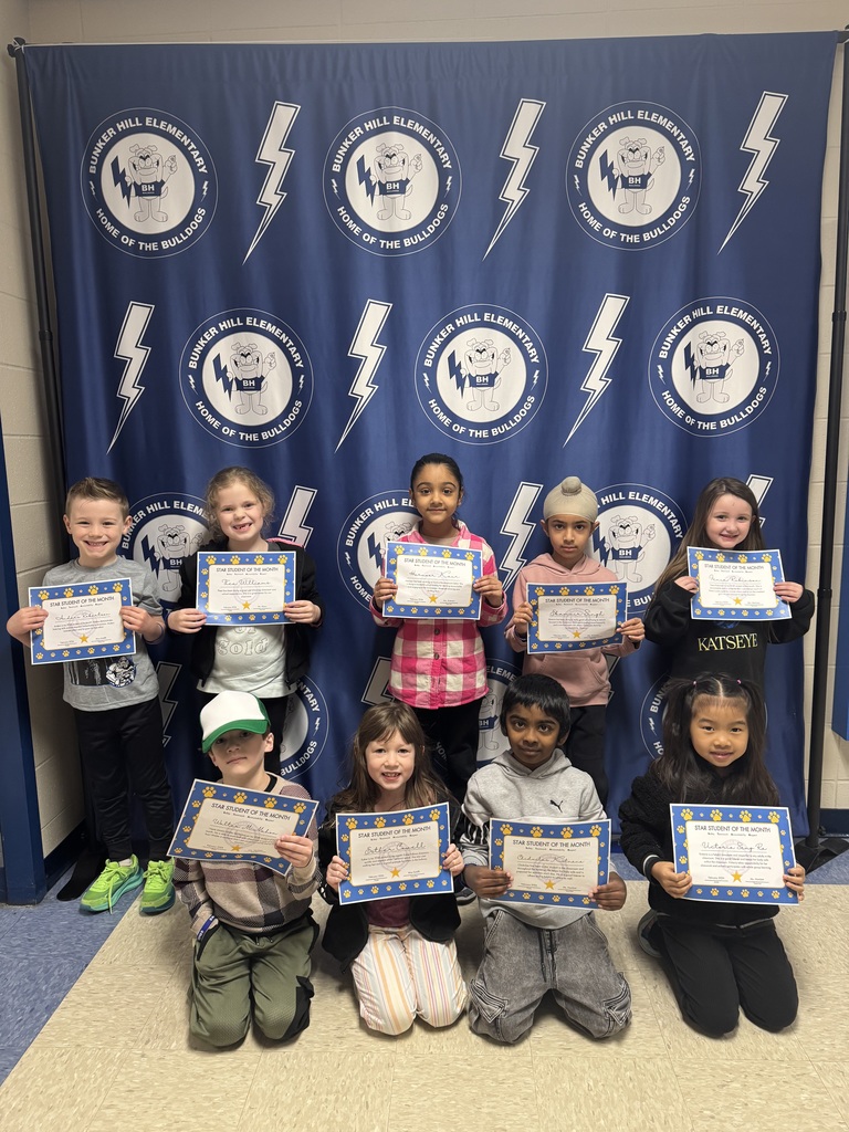 First grade star students of the month holding their certificates