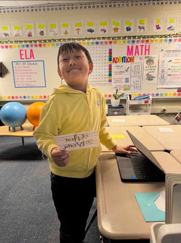 second grader holding letter of encouragement