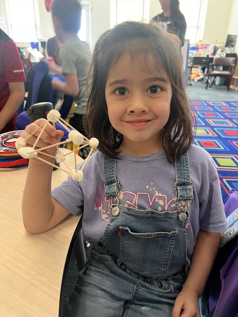 kindergarten student building a shape out of toothpicks and marshmallows 