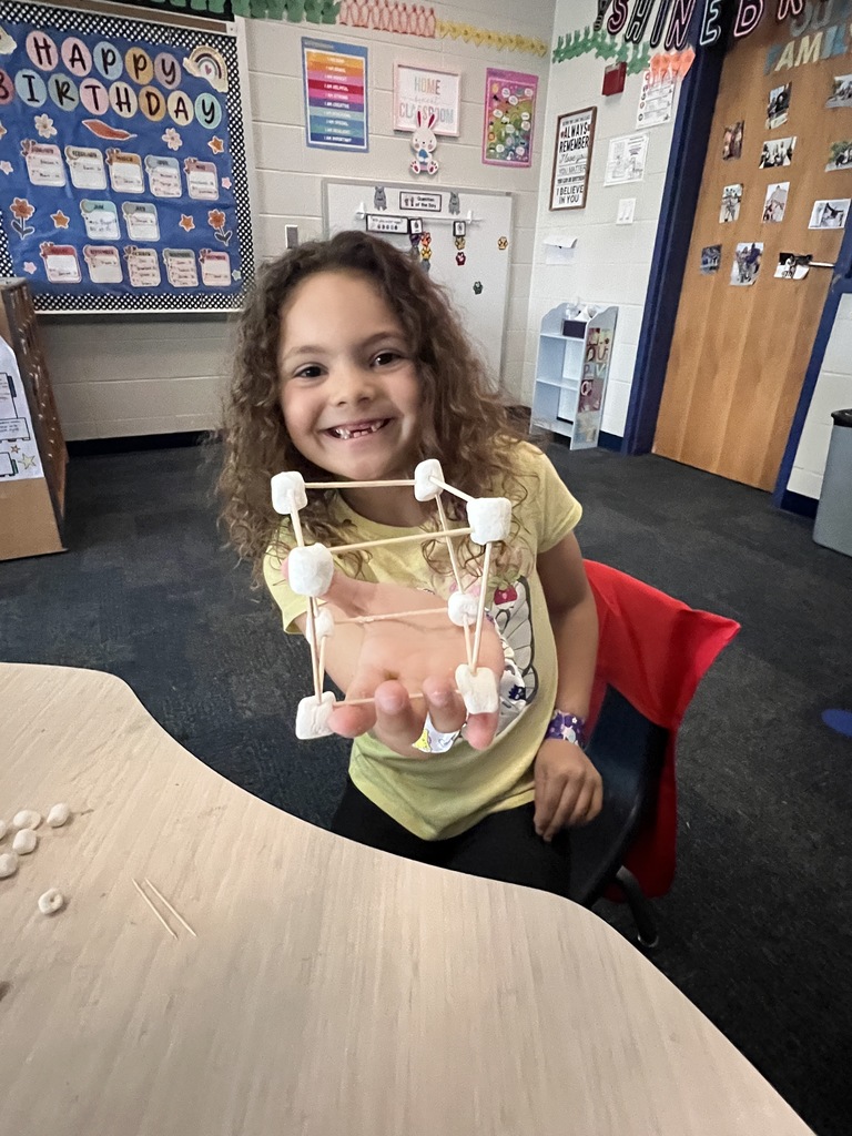 kindergarten student building a shape out of toothpicks and marshmallows 