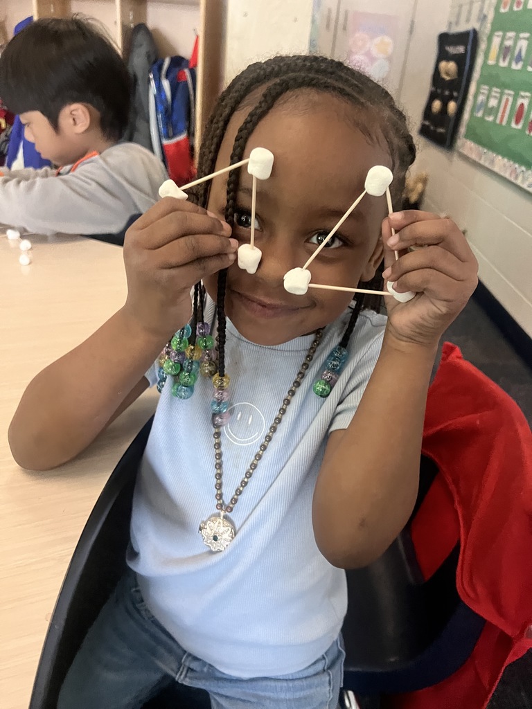 kindergarten student building a shape out of toothpicks and marshmallows 