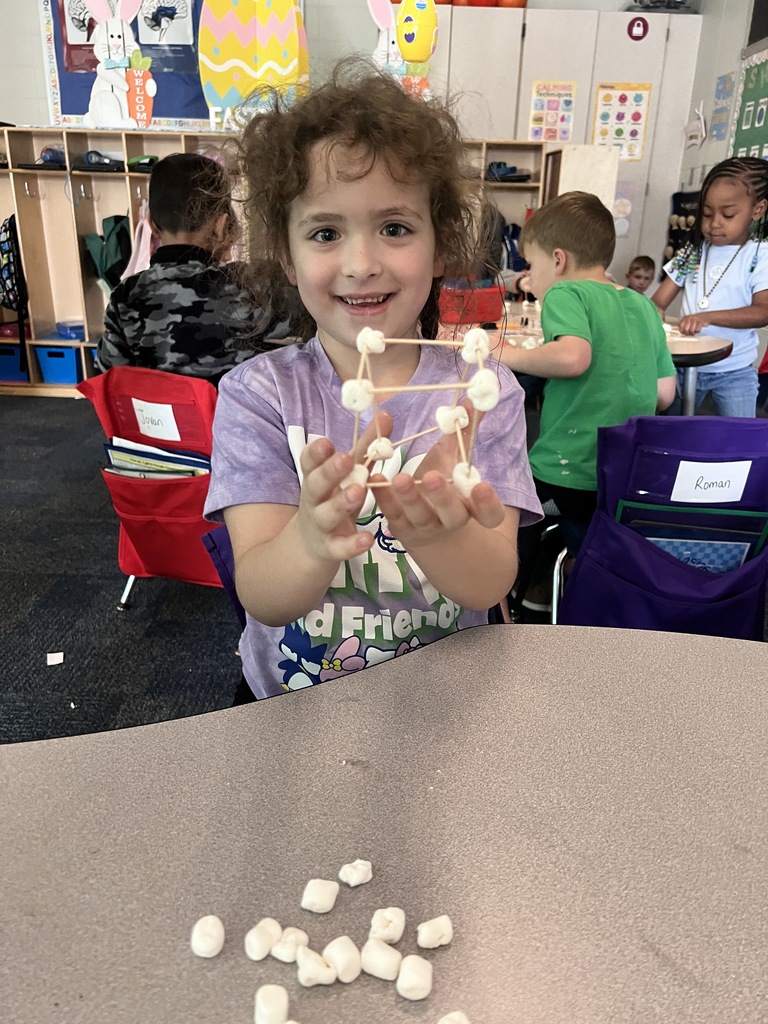 kindergarten student building a shape out of toothpicks and marshmallows 