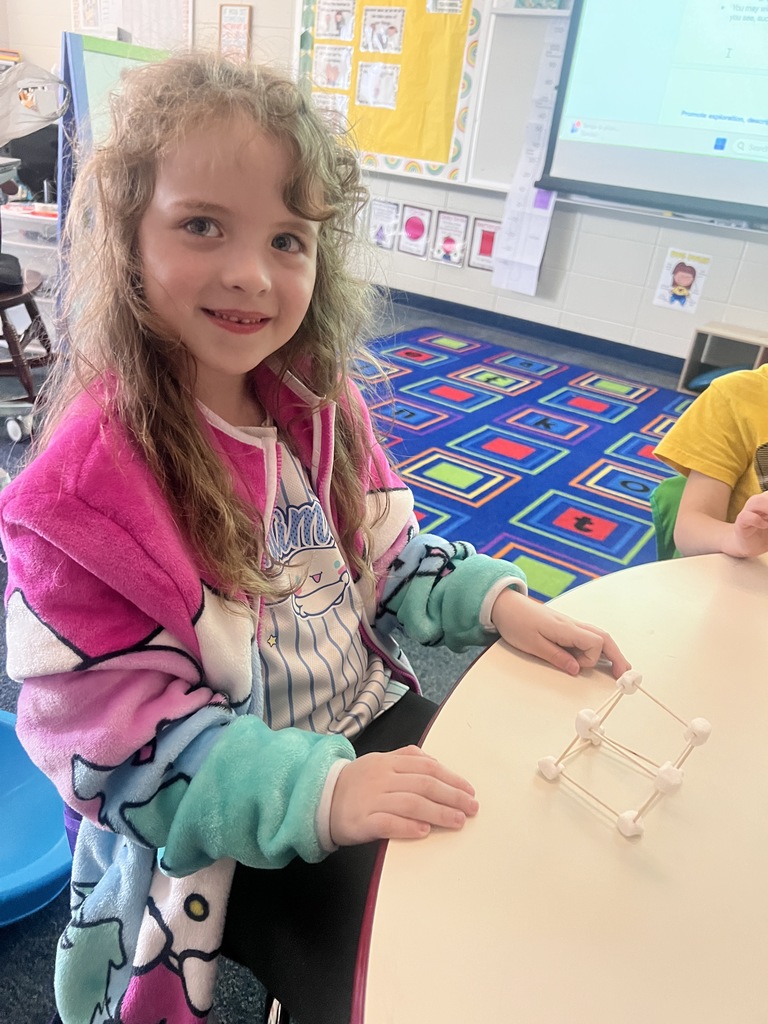 kindergarten student building a shape out of toothpicks and marshmallows 