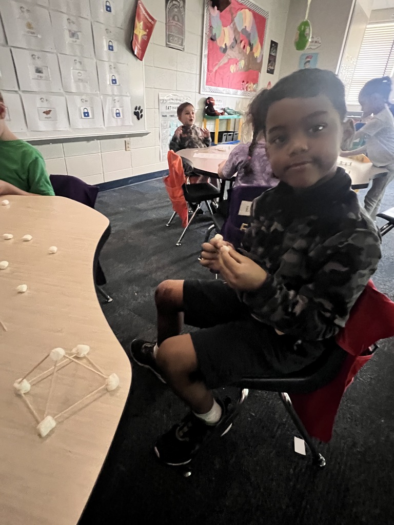 kindergarten student building a shape out of toothpicks and marshmallows 