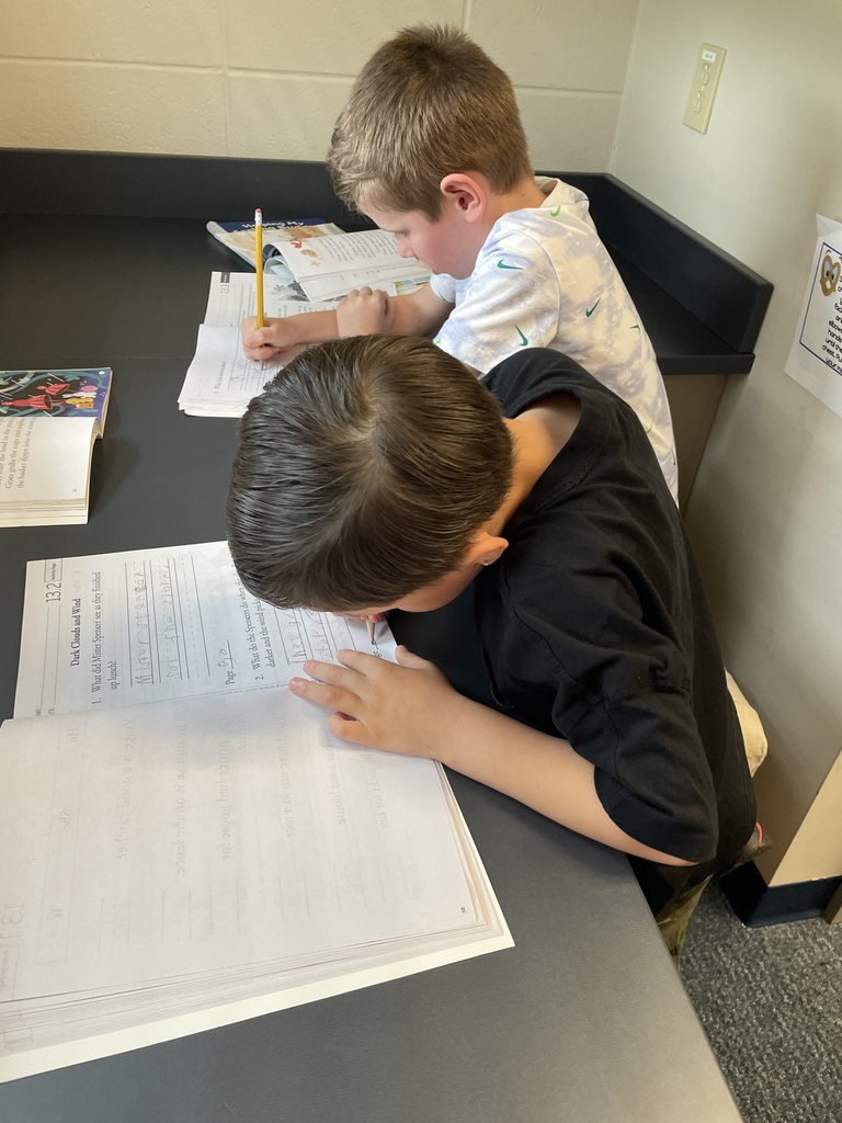 first grade students working in workbooks during class